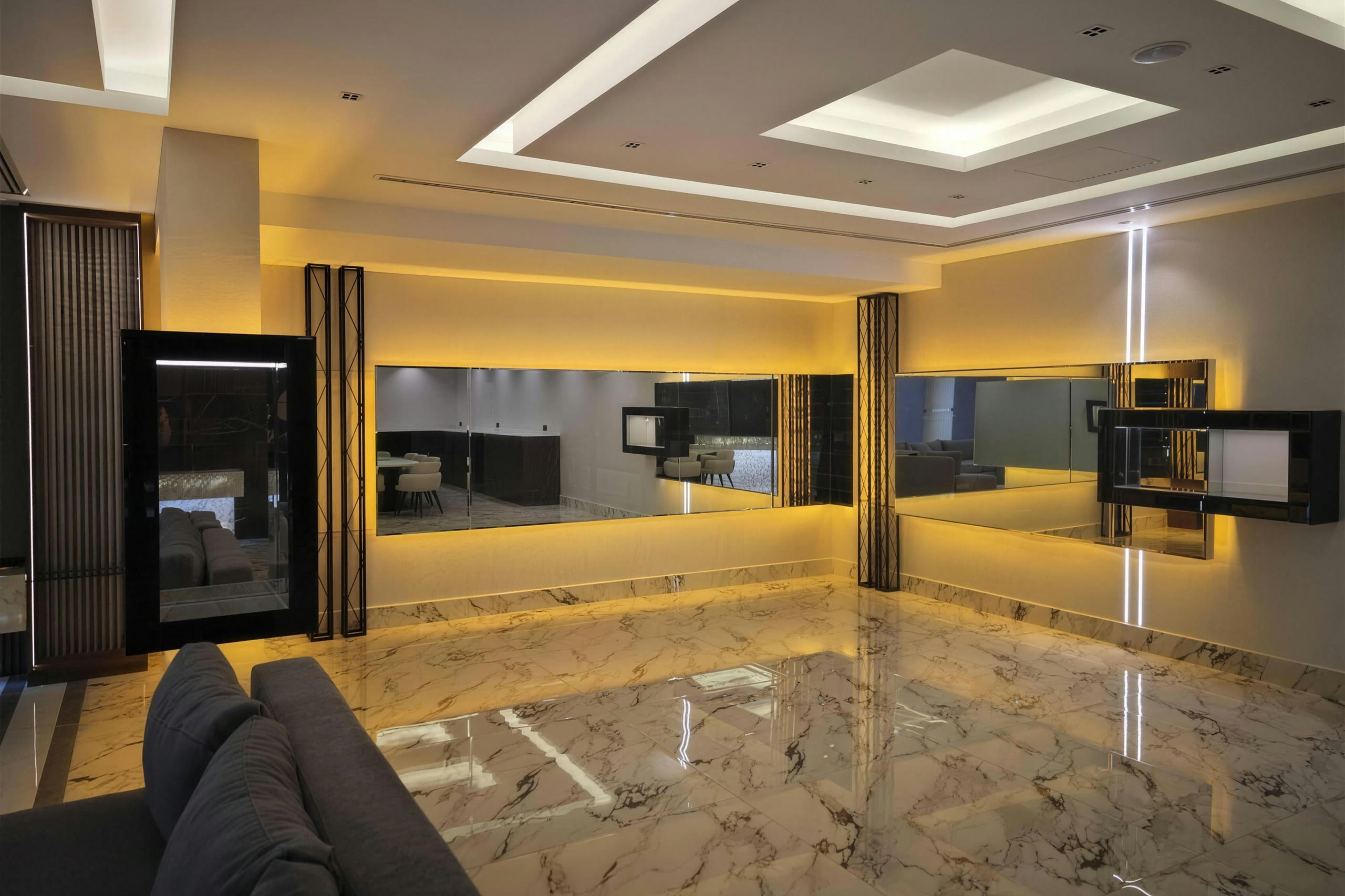 Lounge with backlit mirror recesses, cove lighting and marble floor